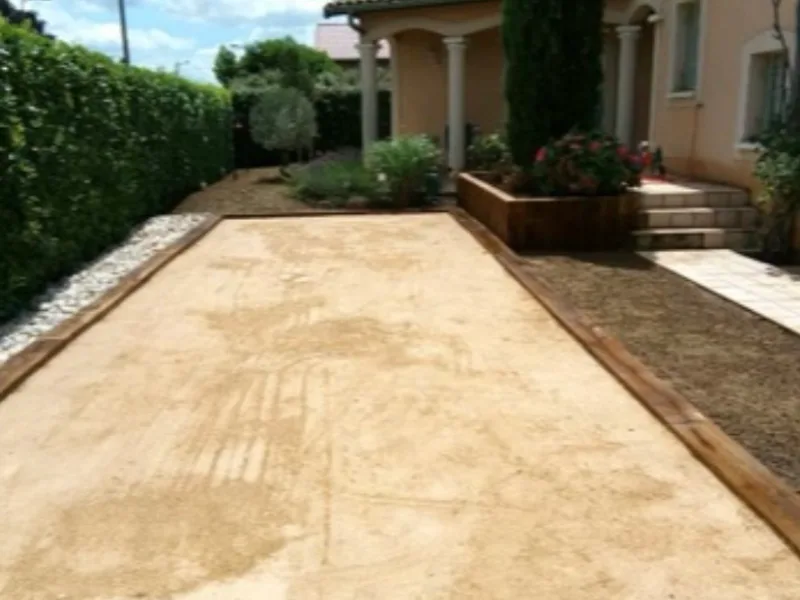 Terrain de petanque borde de traverses en bois et gravier stabilise, maconnerie paysagere a Tarbes