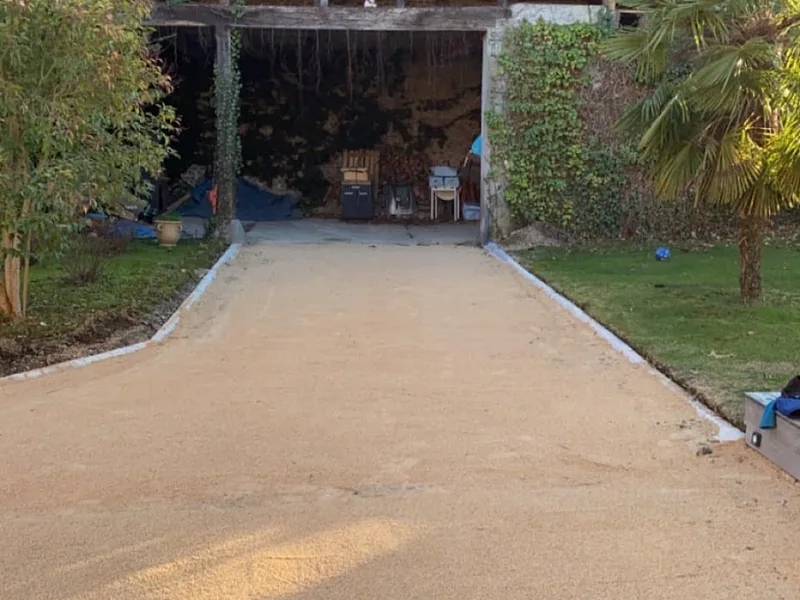 Allee en gravier stabilise devant un batiment en pierre, amenagement mineral a Tarbes