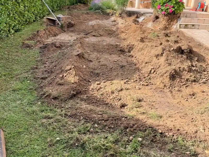 Travaux de terrassement et préparation de sol le long d'une maison à Tarbes